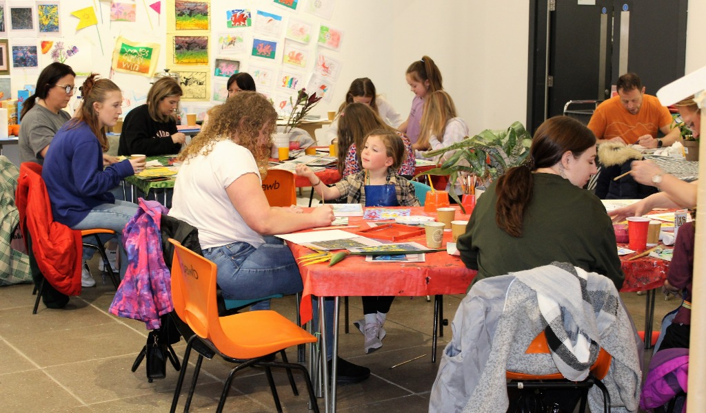 Families creating artwork in the Useful Art Space.