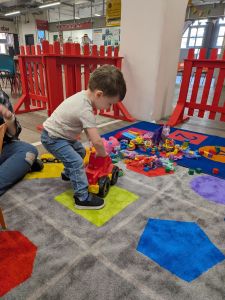 A preschool aged child plays in the Mombies play area.