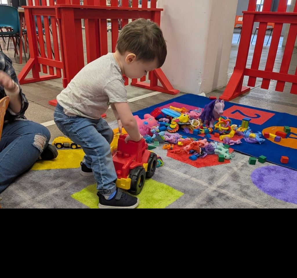 A preschool aged child plays in the Mombies play area.