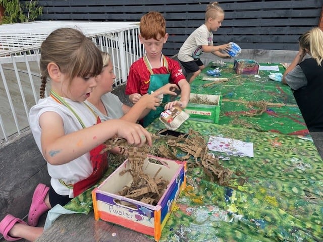 Children making bug hotels in our rooftop garden.